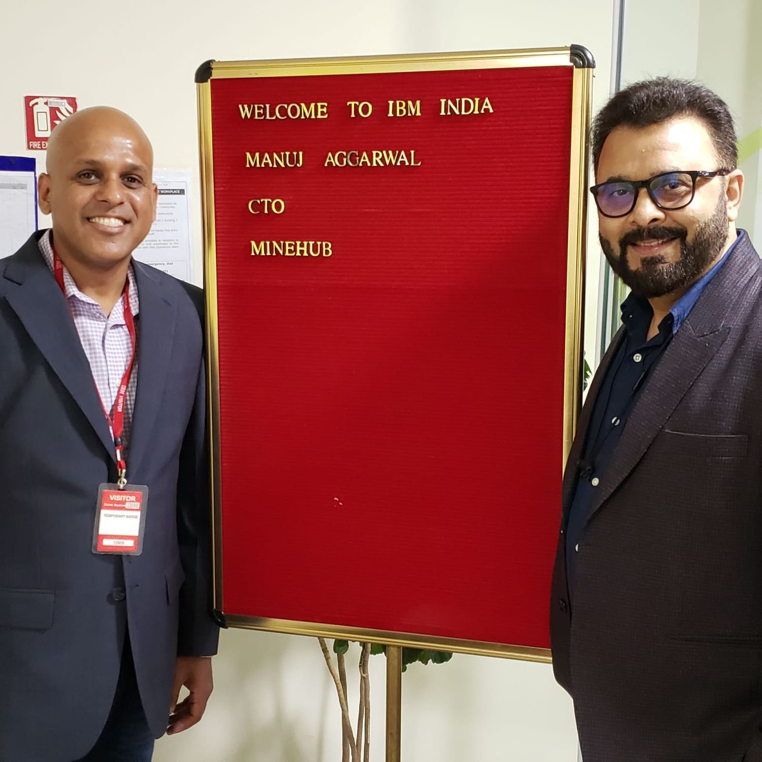 Manuj Aggarwal standing beside a red felt letterboard at IBM India reading: Welcome to IBM India, Manuj Aggarwal, CTO, MineHub.