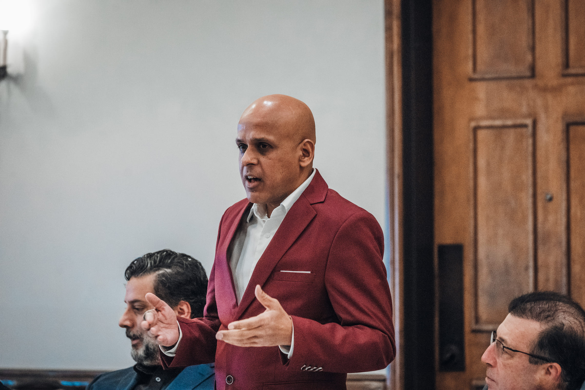 Manuj Aggarwal, present day, speaking to a small room of people.
